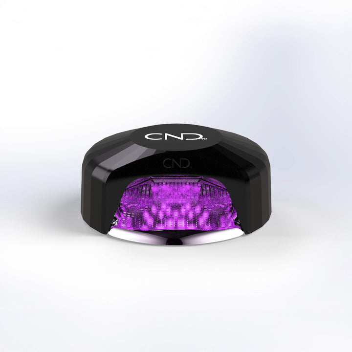 CND nail lamp with purple light on a white background