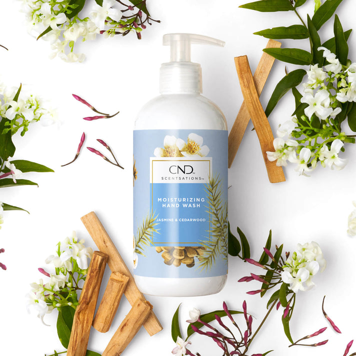 CND Scentsations Moisturizing Hand Wash with floral and cinnamon sticks on a white background