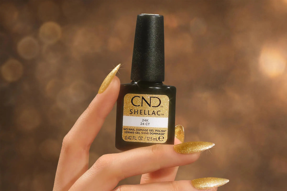 Bottle CND SHELLAC 24K from Glittercore collection held on finely manicured glittery nails. 